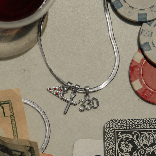 Casino-themed items, including poker chips, dice, a card, and a glass of red wine on a table. Silver Youngstown Ohio Necklace